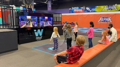 Two girls interact with a iWall at SuperPark.